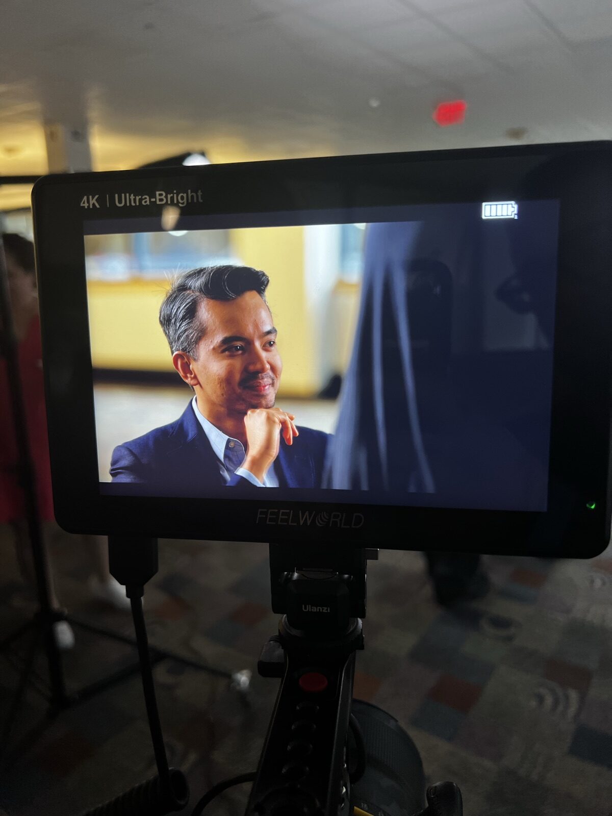 Field monitor showing a close-up of an interview participant during a JGI Media corporate documentary shoot