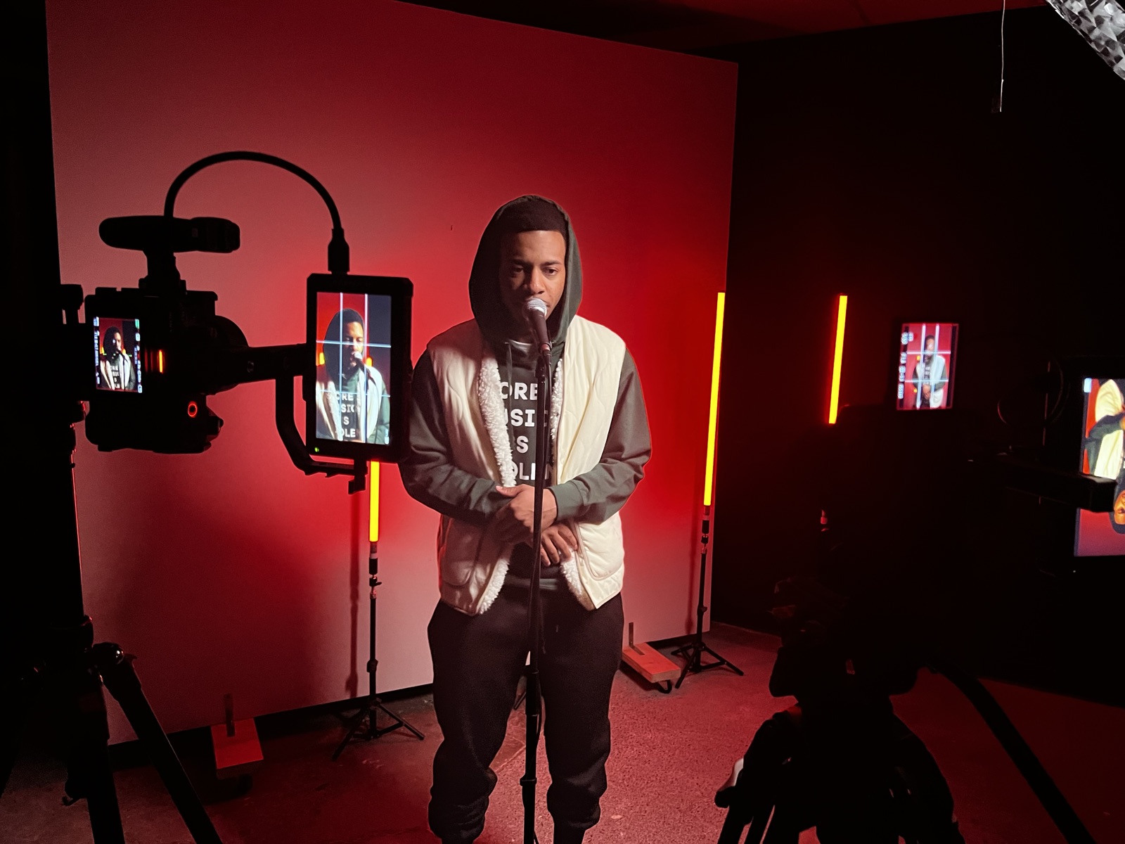 Artist performing at a microphone during a music video shoot at JGI Media in Albany, NY